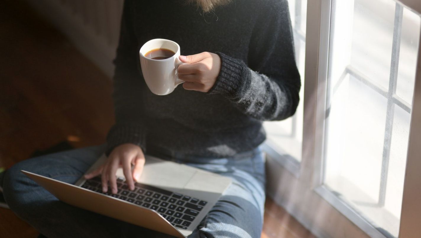 Kvinne med laptop og kaffekopp